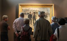 a group of people standing in front of a painting