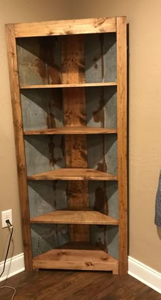 a wooden book shelf sitting on top of a hard wood floor next to a wall