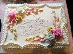 a birthday cake with flowers on it sitting on a table