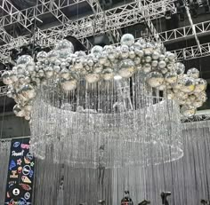 a large chandelier hanging from the ceiling in an indoor event space with people standing around it