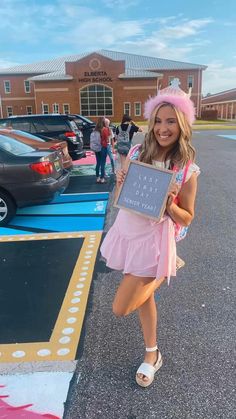 a woman in a pink dress holding up a sign