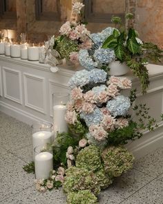 an arrangement of flowers and candles on the floor