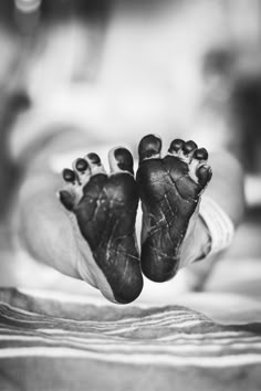 a black and white photo of two baby feet