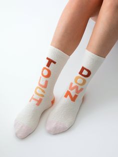 Make a statement with your style in Shiraleah’s “Touchdown” Socks. These tall socks feature the words “Touch” and “Down" on the front of either sock in brown and pink multicolored letters on a white background. The perfect height to share their statement above your favorite pair of shoes, these adorable and feminine socks set the tone for a day of sporting celebration. Pair with other items from Shiraleah’s Gameday Collection to complete your look! Shiraleah is a trend-driven lifestyle brand foc Feminine Socks, Spa Wraps, Tall Socks, Touch Down, Accessories Display, Brown And Pink, Denim Outerwear, Framed Gifts, Zip Pouch