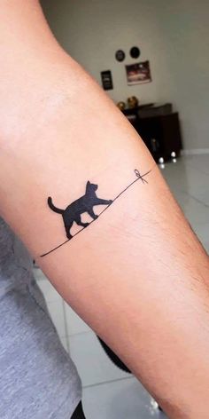 a black cat on a wire tattoo on the arm