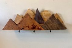 three wooden mountains are hanging on the wall