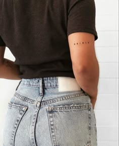 the back of a woman's jeans showing her lower body and upper half with small letters on it