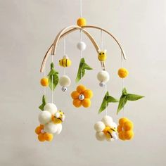 a yellow and white mobile with flowers hanging from it