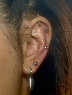 a woman's ear with several piercings on it