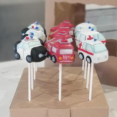 cake pops with cars on them in the shape of firetrucks and ambulances