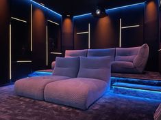 a couch sitting on top of a carpet covered floor next to a wall filled with lights