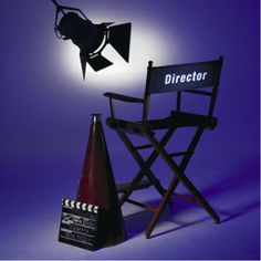 a director's chair next to a traffic cone with a light on it and a movie projector