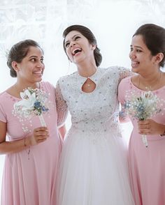 three bridesmaids laughing together in front of a window