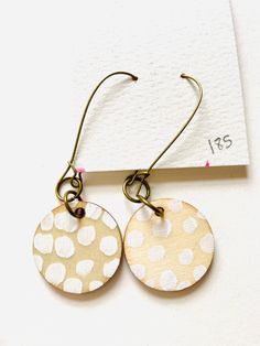 Art adorns your home and spaces but have you ever wanted to wear art in a fun, unique way? I've created these mixed media earrings with you in mind! Trendy hand painted earrings are ready to help you make a statement! Did I mention that they're double sided, too? The front side features a bold, abstract painting with gold shimmery accents and the back is complete with a fun pattern painted in white. Very light weight and easy to wear! What they're made with: - light weight wooden disc - acrylic Artistic White Drop Earrings, Artisan Hand Painted Earrings For Gift, Artistic Hand Painted White Earrings, Unique Hand Painted Everyday Earrings, Unique Hand Painted Earrings For Everyday, Unique Hand Painted White Earrings, Everyday Hand Painted Gold Earrings, Unique Hand Painted Earrings For Everyday Wear, Artistic White Round Earrings