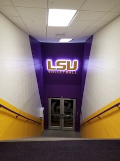 an entrance to the lsu volleyball team's locker room with purple and yellow walls