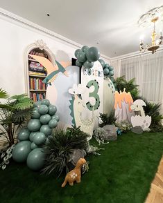 a room decorated with balloons and decorations for a dinosaur themed birthday party or baby shower