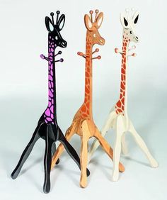 three wooden giraffes are standing next to each other on a white background