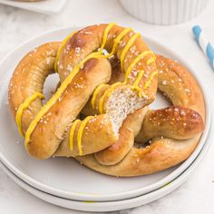 a white plate topped with pretzels covered in yellow icing and sprinkles