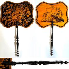 two decorative wooden plaques with black and gold designs on them, one is holding a cane