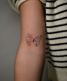 a woman's arm with a butterfly tattoo on the left side of her arm