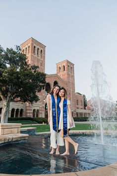 two young women standing in front of a fountain