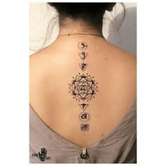 the back of a woman's neck with an intricate tattoo design on her left shoulder