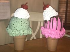 two ice cream cones sitting on top of a wooden table