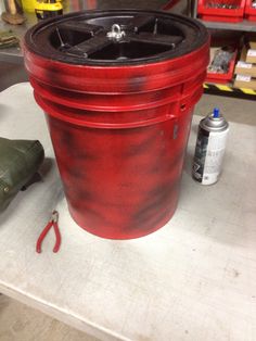 a red bucket sitting on top of a table