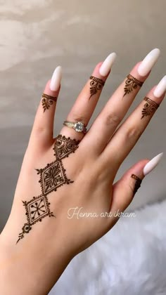 a woman's hand with henna tattoos on it