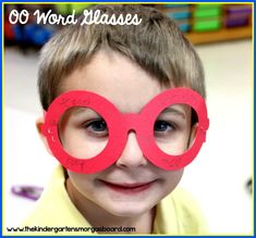 a young boy wearing red paper glasses with writing on the front and side of his eyes