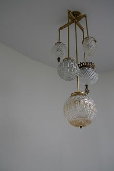 a chandelier hanging from the ceiling in a room with white walls and flooring