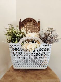 a basket filled with flowers sitting on top of a wooden chair