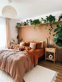 a bed in a bedroom with plants on the headboard and rugs around it