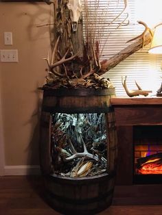 a wooden barrel with antlers on top in front of a fireplace