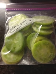 a bag filled with green pickles sitting on top of a counter