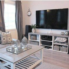 a living room filled with furniture and a flat screen tv mounted to the side of a wall