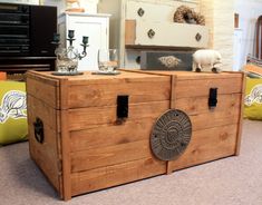 a wooden trunk with two glasses on top of it in front of a dresser and other furniture