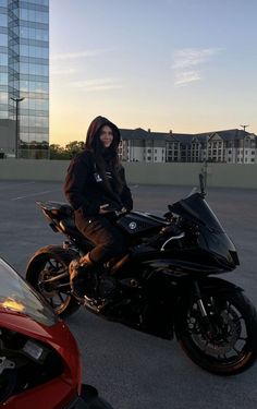 a person sitting on a motorcycle in a parking lot