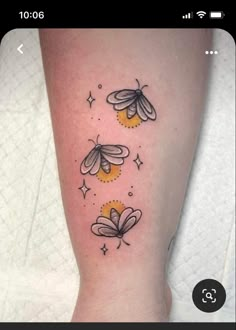 a woman's leg with three bees on it and stars in the sky above