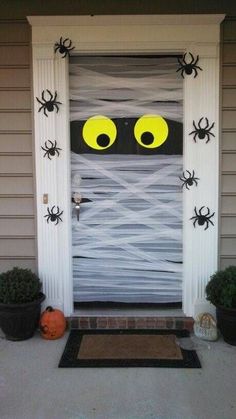 a front door decorated for halloween with spider webs and eyes