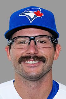 a man with glasses and a mustache wearing a toronto blue jackets baseball cap is smiling at the camera