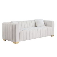 a white couch with gold legs and pillows