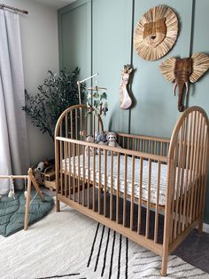 a baby crib in the corner of a room with two deer heads on the wall