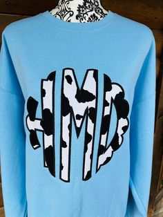 "Large Scalloped Cow Print Monogram Sweatshirt made to your specifications.  The monogram is approx. 9.5 - 10\" tall  ** Now available in Hanes Comfort wash similar to Comfort Colors**   Made with great quality sweatshirts, fabrics, and thread.   The pictures are just a sample of what can be done.  I can customize this to your desire on the style of shirt you choose in the options.  Please choose your shirt color & style. Please NoteNO REFUNDS OR RETURNS due to these are made to order.   You can send an Idea and I will create a finished product for you.   PLEASE NOTE Monograms are stitched as follows 1st initial, LAST initial (middle), middle initial.    In the personalization box please list as 1st name , middle initial, Last name so I can get your monogram correct. Once the order has bee Nike Cow Print Sweatshirt, Cow Nike Sweatshirt, Cow Print Monogram, Cow Print Sweatshirt, Cow Print Mama Shirt, Cotton T-shirt With Cow Print And Crew Neck, Monogram Sweatshirt, Embroidery Sweatshirt, Monogram Shirts