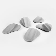 five pieces of stone sitting on top of a white surface with one piece missing from it