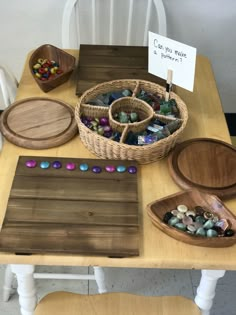 a wooden table topped with lots of different types of rocks and stones in baskets on top of it