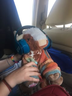 a person holding a stuffed animal with headphones on