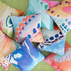 several colorful pillows are arranged on a green surface