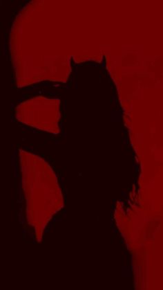 the silhouette of a person with long hair and an animal's head is shown against a red background