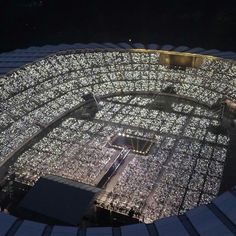 an aerial view of the stadium's seating area at night, with lights on it